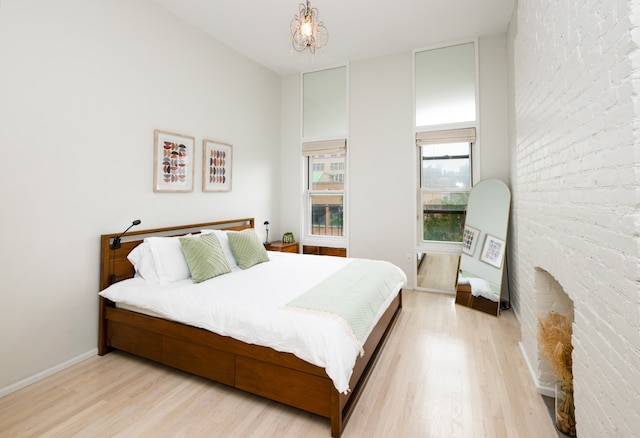 bedroom featuring an inviting chandelier and light hardwood / wood-style flooring