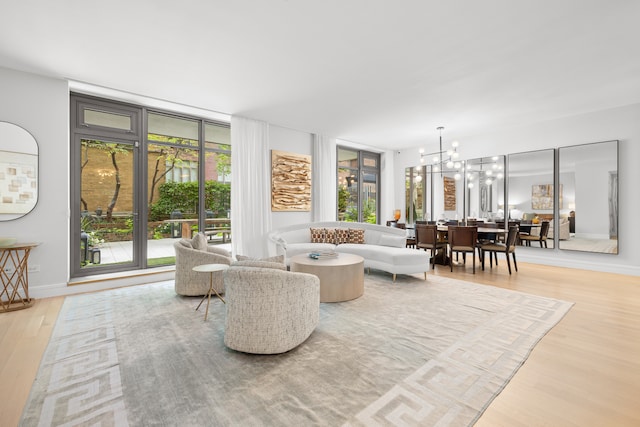 living room featuring light hardwood / wood-style floors, an inviting chandelier, and a wealth of natural light