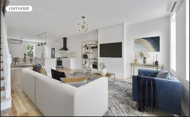 living room with light hardwood / wood-style floors, a wall mounted AC, sink, and a chandelier