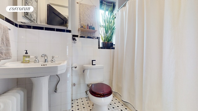 bathroom featuring radiator heating unit, tile patterned flooring, toilet, tile walls, and a shower with shower curtain