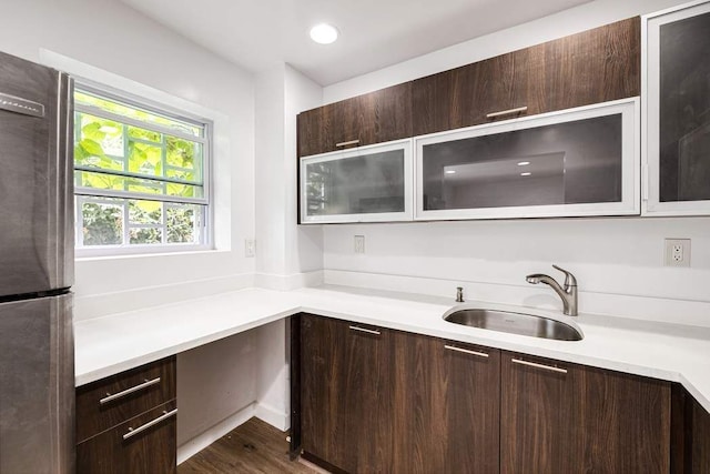 kitchen featuring stainless steel refrigerator, dark brown cabinetry, sink, and dark hardwood / wood-style flooring