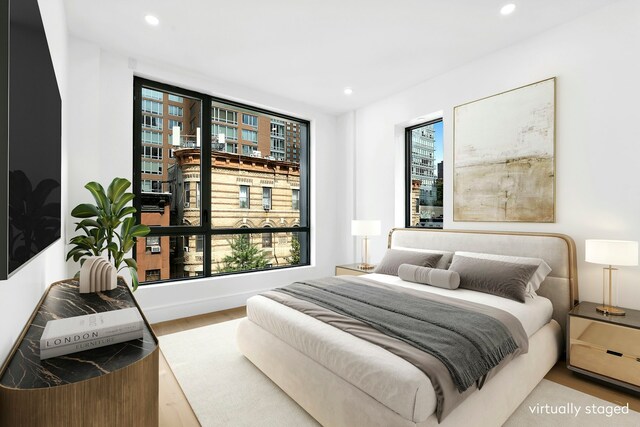 bedroom with multiple windows and hardwood / wood-style floors