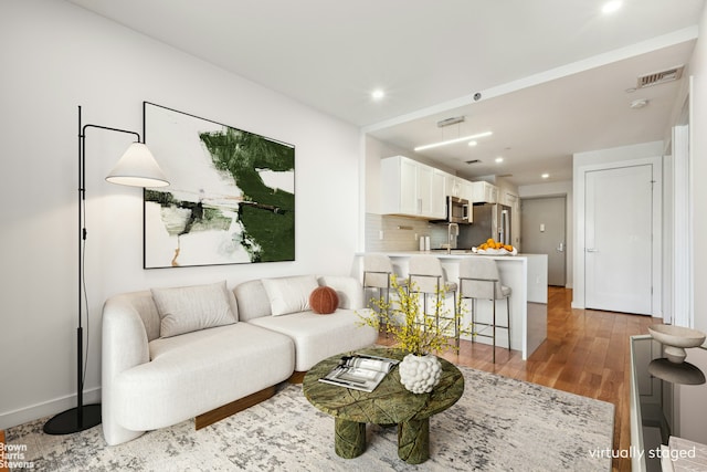 living room featuring sink and hardwood / wood-style flooring