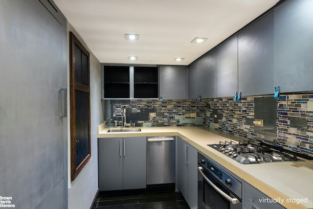 kitchen with appliances with stainless steel finishes, sink, and decorative backsplash