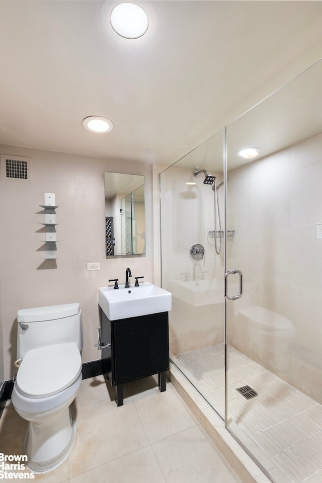 bathroom featuring vanity, toilet, an enclosed shower, and tile patterned floors