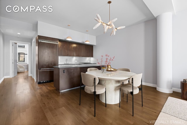 dining area featuring sink and dark hardwood / wood-style flooring