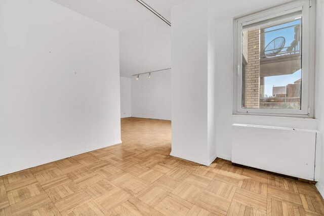 unfurnished room with light parquet floors and plenty of natural light