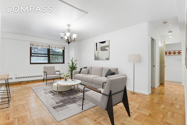 living room with light parquet flooring, a baseboard radiator, and a notable chandelier