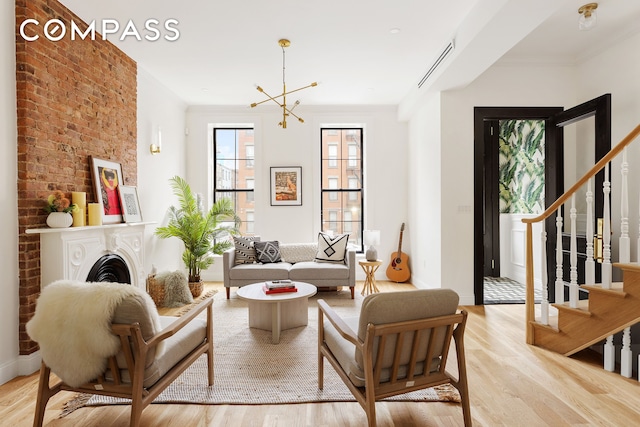 sitting room with an inviting chandelier, light hardwood / wood-style flooring, and ornamental molding