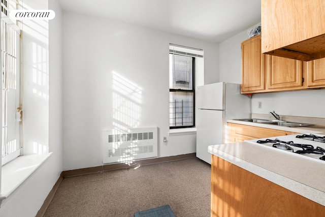 kitchen featuring heating unit, white refrigerator, and sink