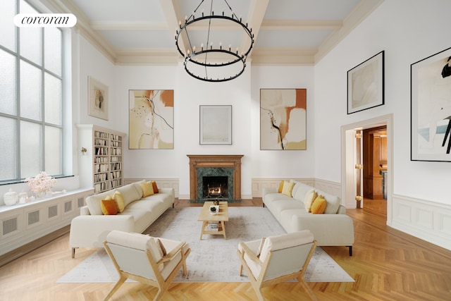 living room with a fireplace, crown molding, beam ceiling, and light parquet floors