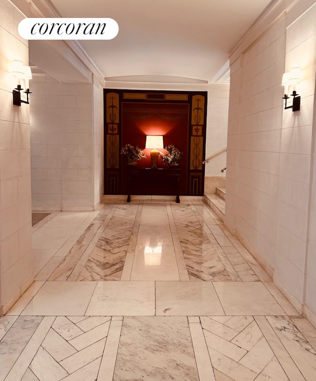 corridor with tile walls and ornamental molding