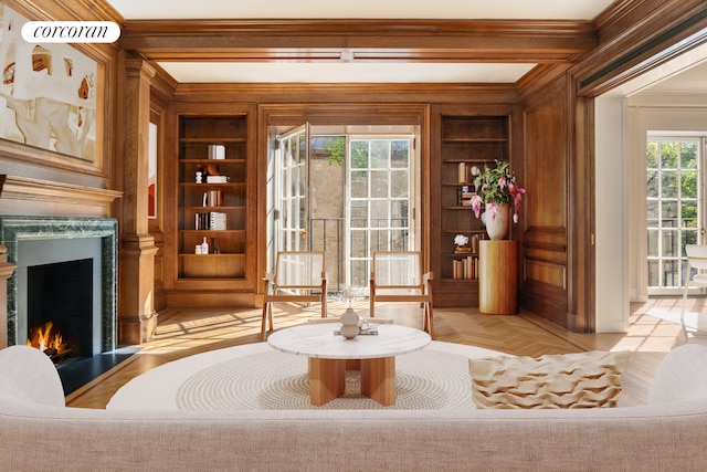 sitting room with light parquet flooring, ornamental molding, and built in features