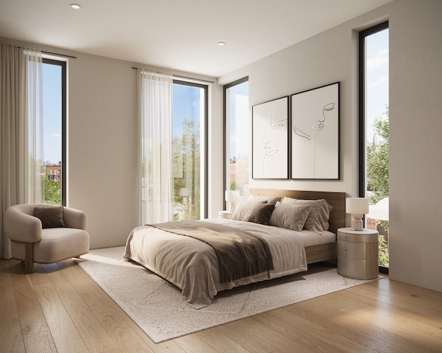 bedroom featuring light hardwood / wood-style flooring, floor to ceiling windows, and multiple windows