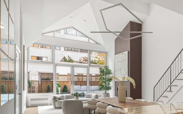 living room with a towering ceiling and radiator heating unit