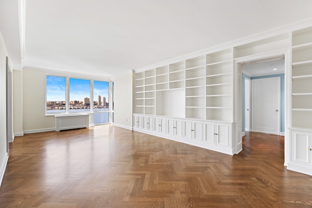 interior space featuring ornamental molding, built in features, and dark parquet flooring