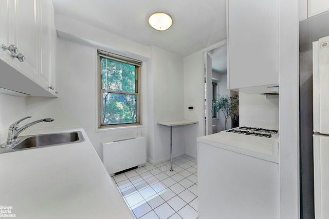 laundry area with light tile patterned flooring and sink