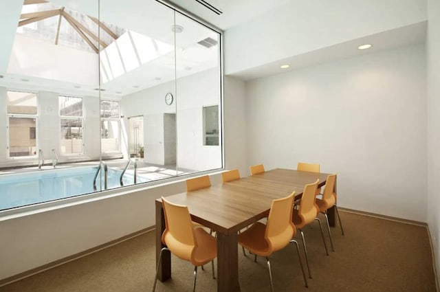 carpeted dining room with a skylight