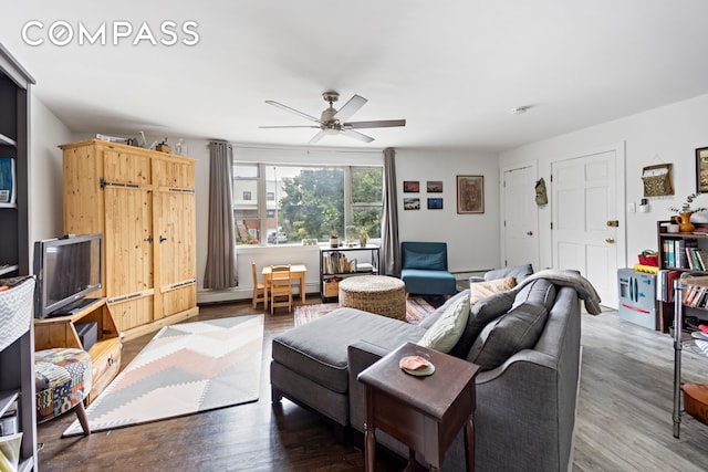 living room featuring ceiling fan and dark hardwood / wood-style floors