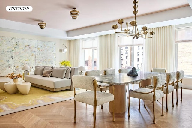 dining space featuring light parquet floors, a healthy amount of sunlight, and an inviting chandelier