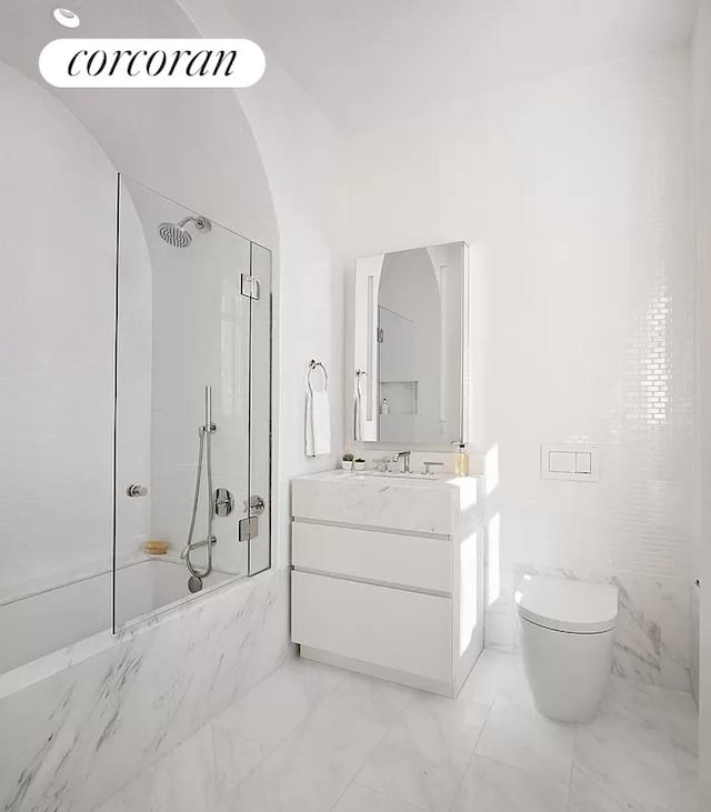 full bathroom with vaulted ceiling, vanity, tiled shower / bath, and toilet