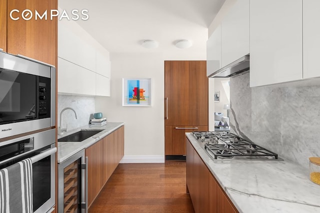 kitchen with sink, beverage cooler, white cabinetry, stainless steel appliances, and dark hardwood / wood-style floors