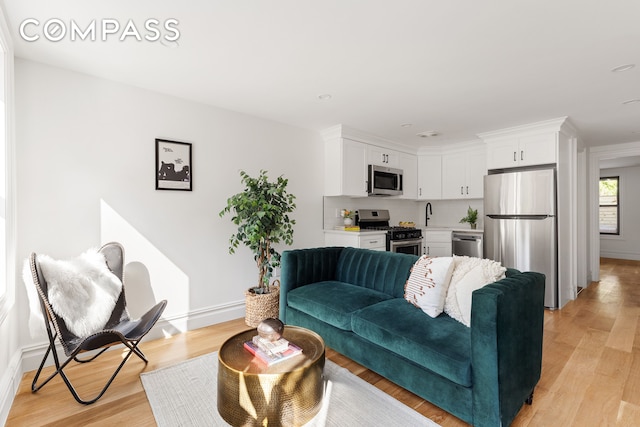 living room featuring sink and light hardwood / wood-style floors