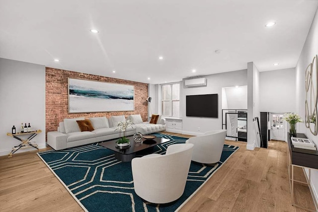 living room with light hardwood / wood-style floors and a wall unit AC