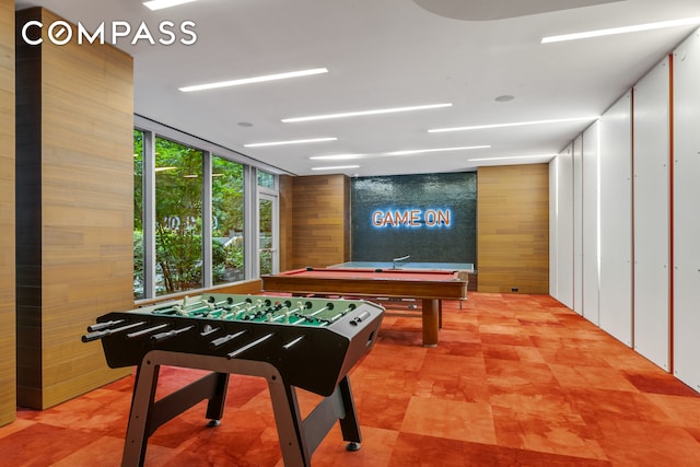 game room with a wall of windows, wooden walls, and pool table