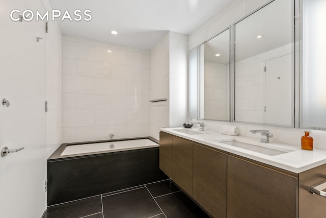 bathroom with vanity, a tub, and tile patterned floors