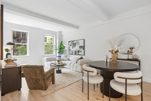 living room with beamed ceiling and light hardwood / wood-style flooring