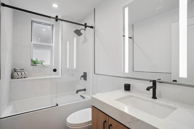 full bathroom with bath / shower combo with glass door, vanity, and toilet