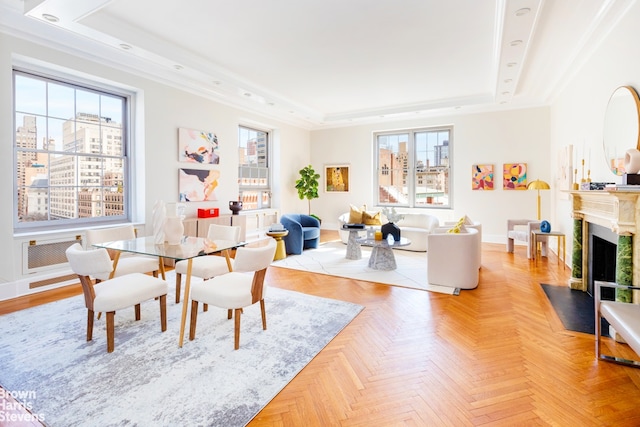 dining space with a raised ceiling, a wealth of natural light, and light parquet flooring