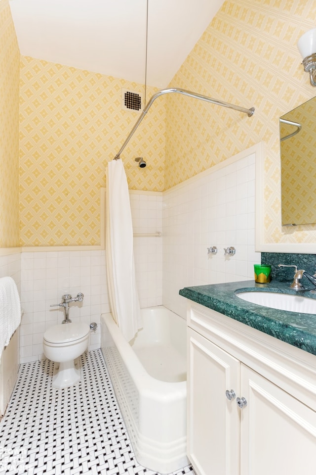 full bathroom featuring shower / tub combo, vanity, toilet, and tile walls