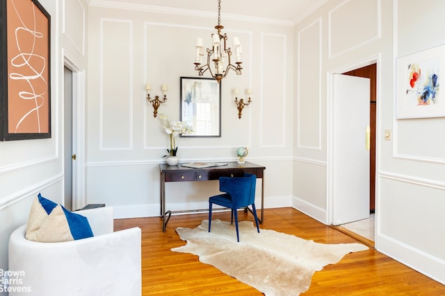 living area with an inviting chandelier, ornamental molding, and hardwood / wood-style flooring