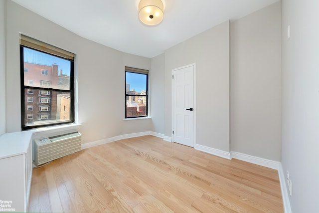 empty room featuring light hardwood / wood-style floors and a wall mounted AC