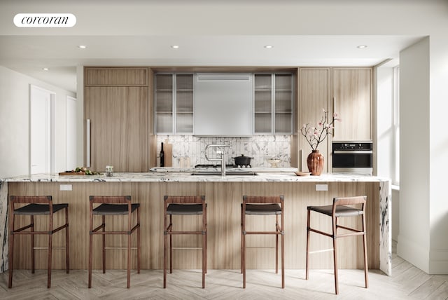 kitchen with a kitchen breakfast bar, backsplash, oven, and light parquet flooring