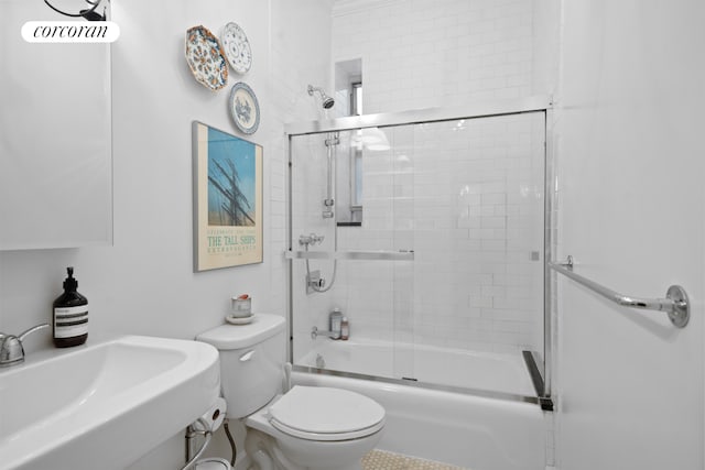 full bathroom featuring shower / bath combination with glass door, sink, and toilet