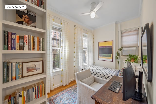 sitting room with built in shelves, hardwood / wood-style floors, ceiling fan, and crown molding