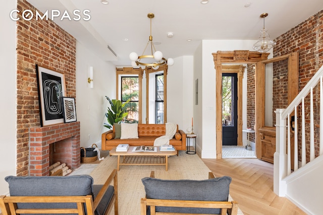 interior space featuring a healthy amount of sunlight, a notable chandelier, light parquet flooring, and a brick fireplace