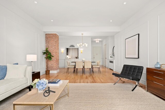 living room with radiator, a chandelier, and light hardwood / wood-style floors