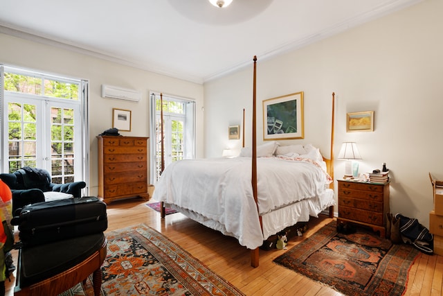 bedroom with multiple windows, ornamental molding, an AC wall unit, and light hardwood / wood-style flooring