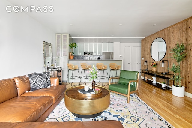 living room featuring wooden walls and light hardwood / wood-style floors