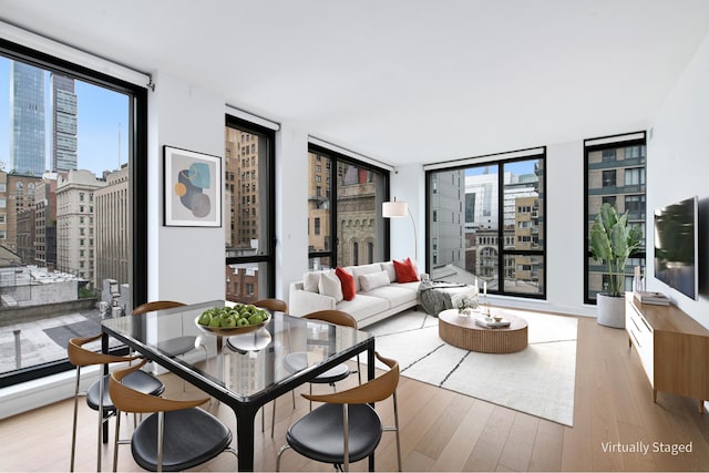 dining area featuring a wall of windows and light hardwood / wood-style flooring