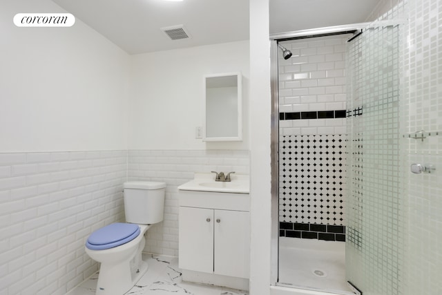 bathroom with an enclosed shower, tile walls, vanity, and toilet