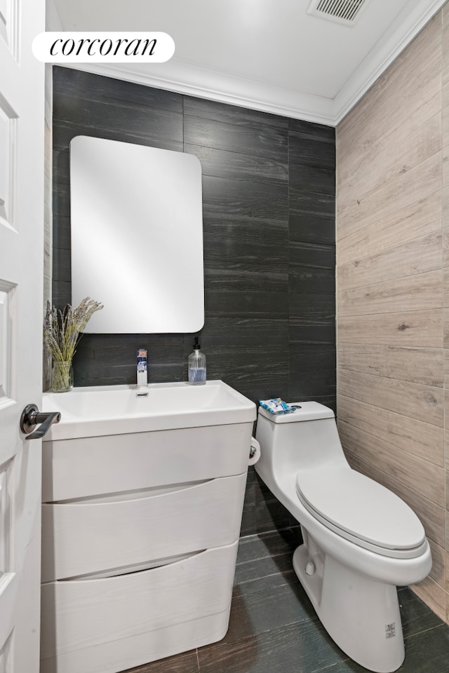 bathroom featuring vanity, tile walls, and toilet