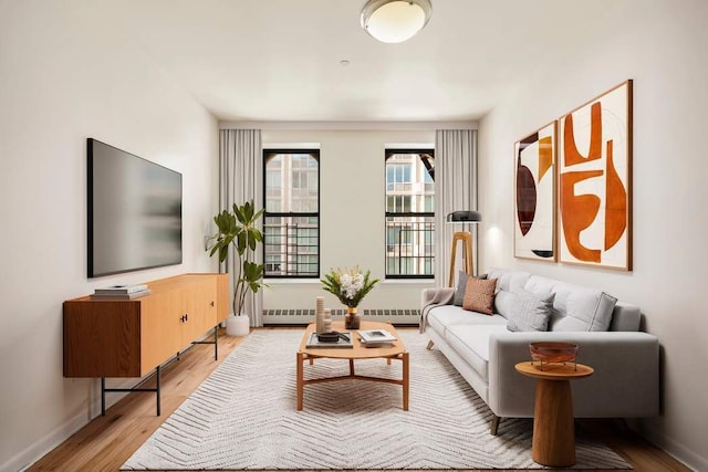 living room with baseboard heating and light wood-type flooring