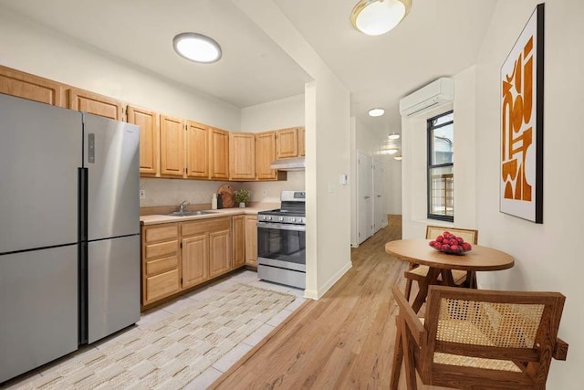 kitchen featuring light brown cabinets, an AC wall unit, stainless steel appliances, sink, and light wood-type flooring