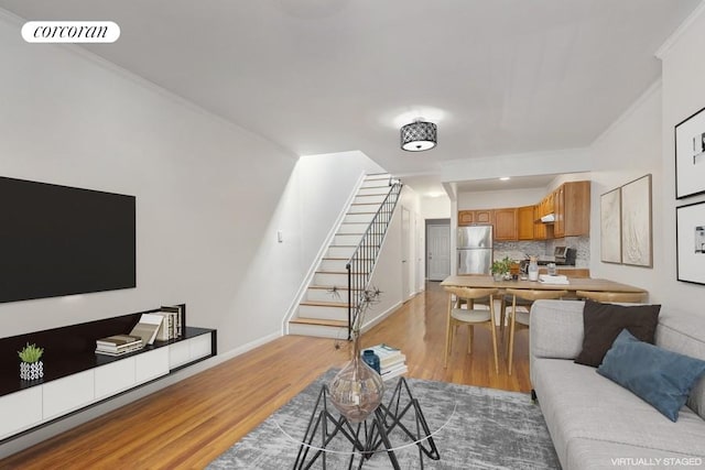 living room featuring crown molding and light hardwood / wood-style floors