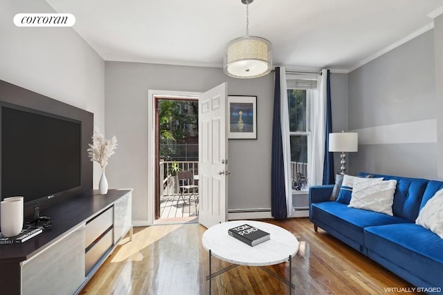 living room featuring hardwood / wood-style flooring, plenty of natural light, ornamental molding, and a baseboard heating unit